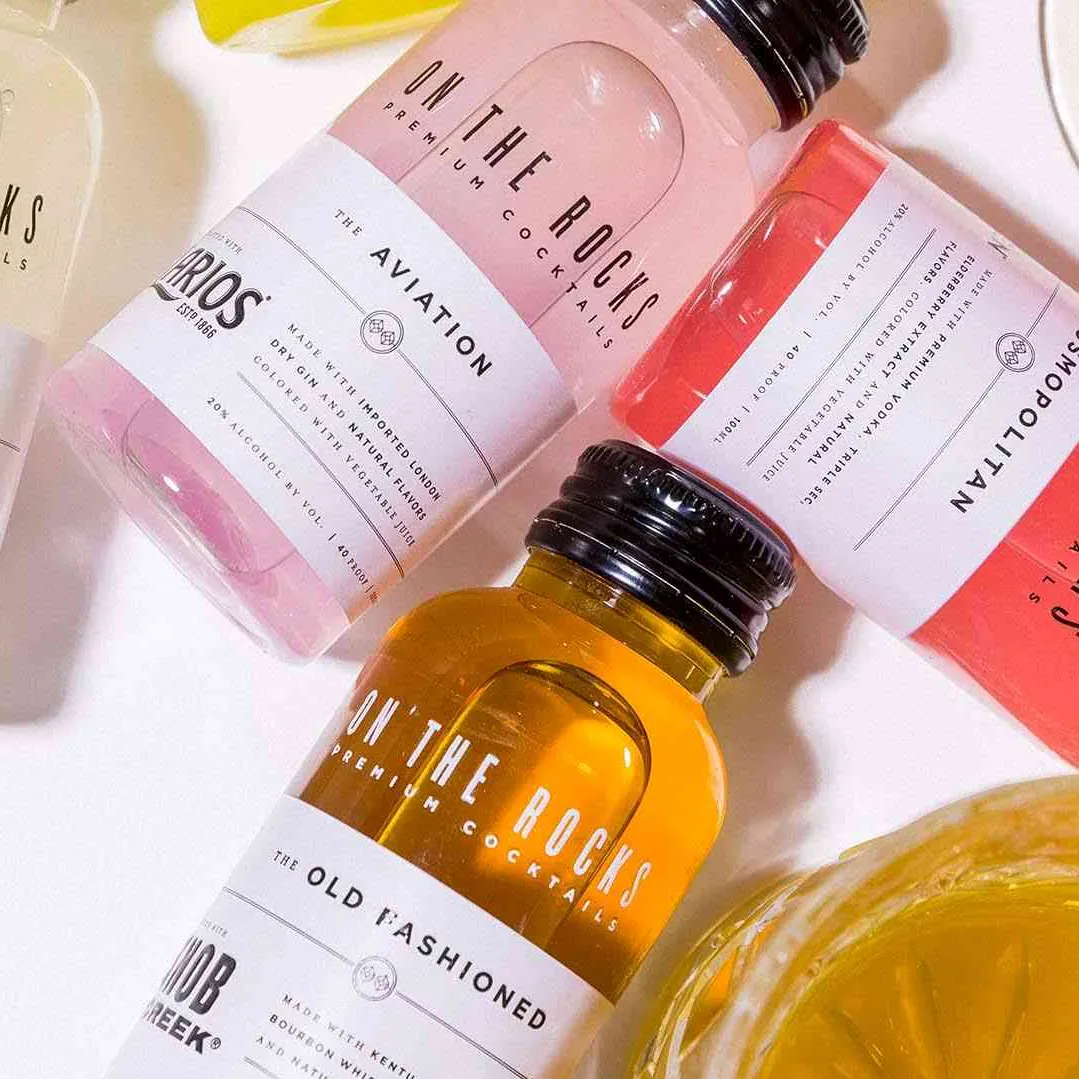 Close up of multiple colourful small OTR cocktail bottles with old fashioned and cosmopolitan cocktails.