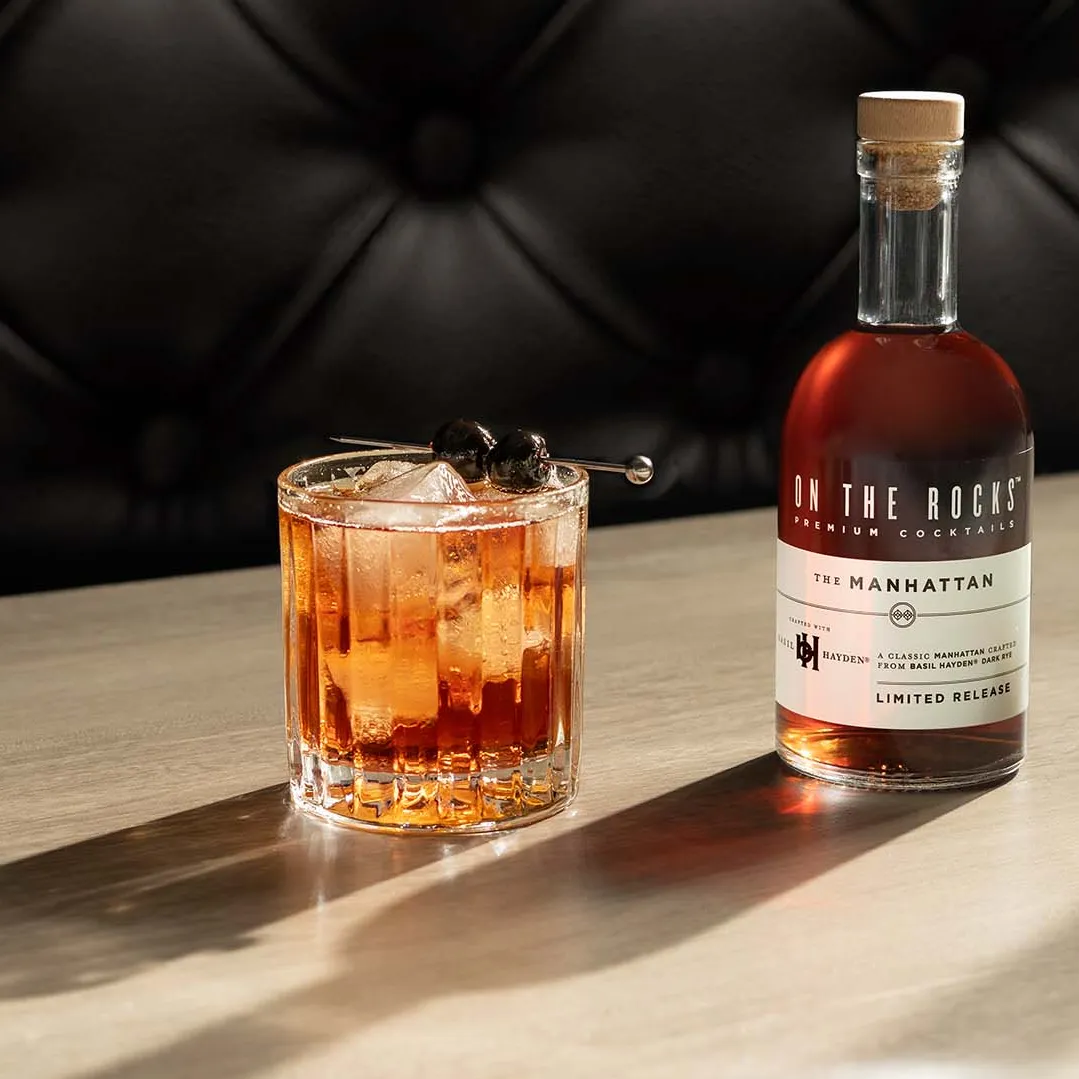A bottle and a glass of OTR Manhattan cocktail at bar