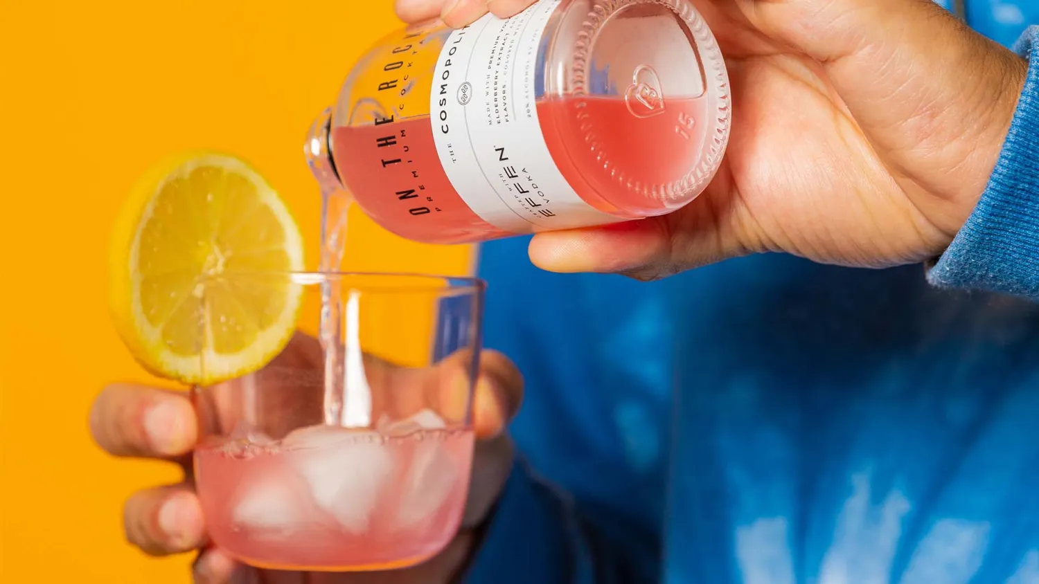 Pouring OTR Cosmopolitan cocktail into a glass