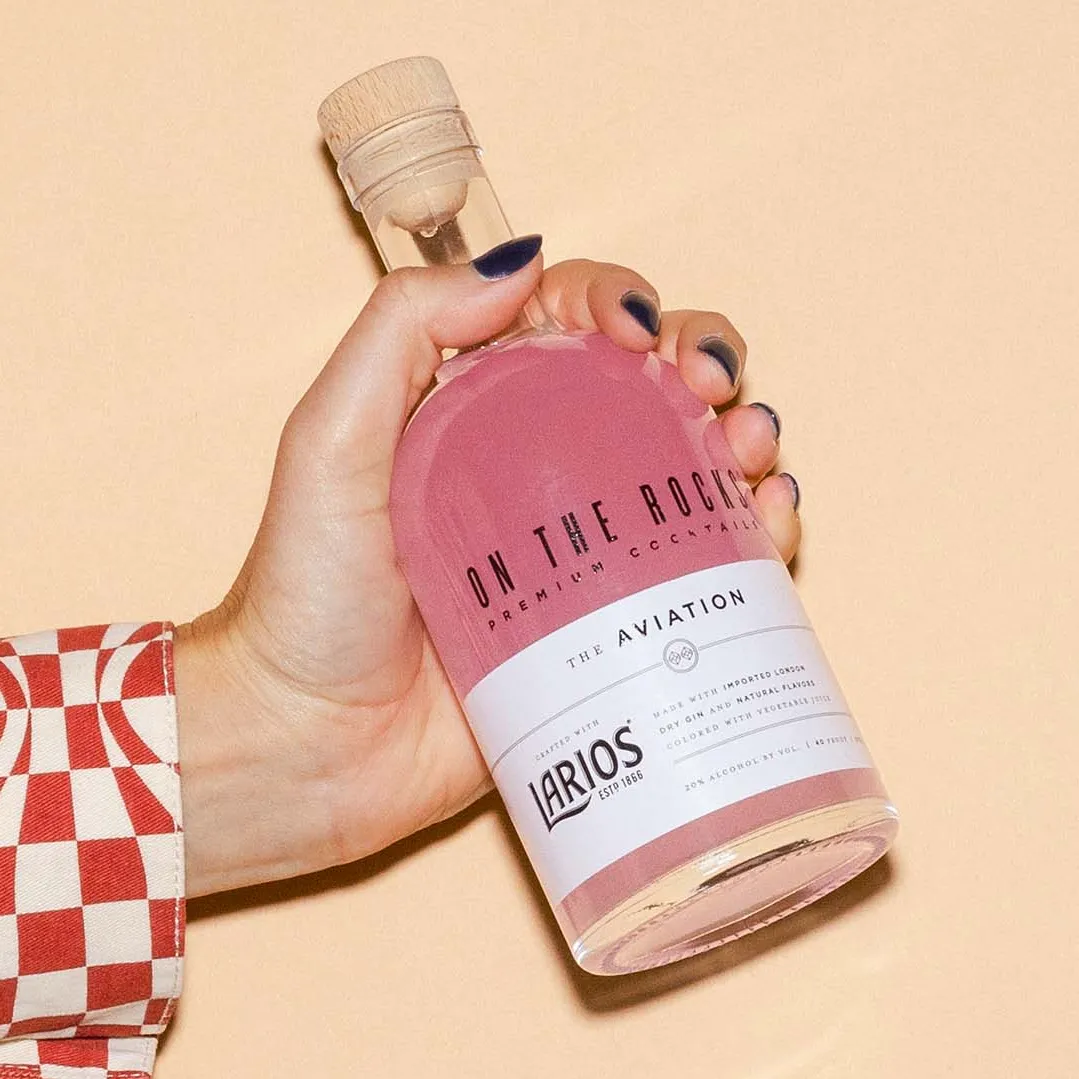 Woman is holding a bottle of OTR Aviation cocktail