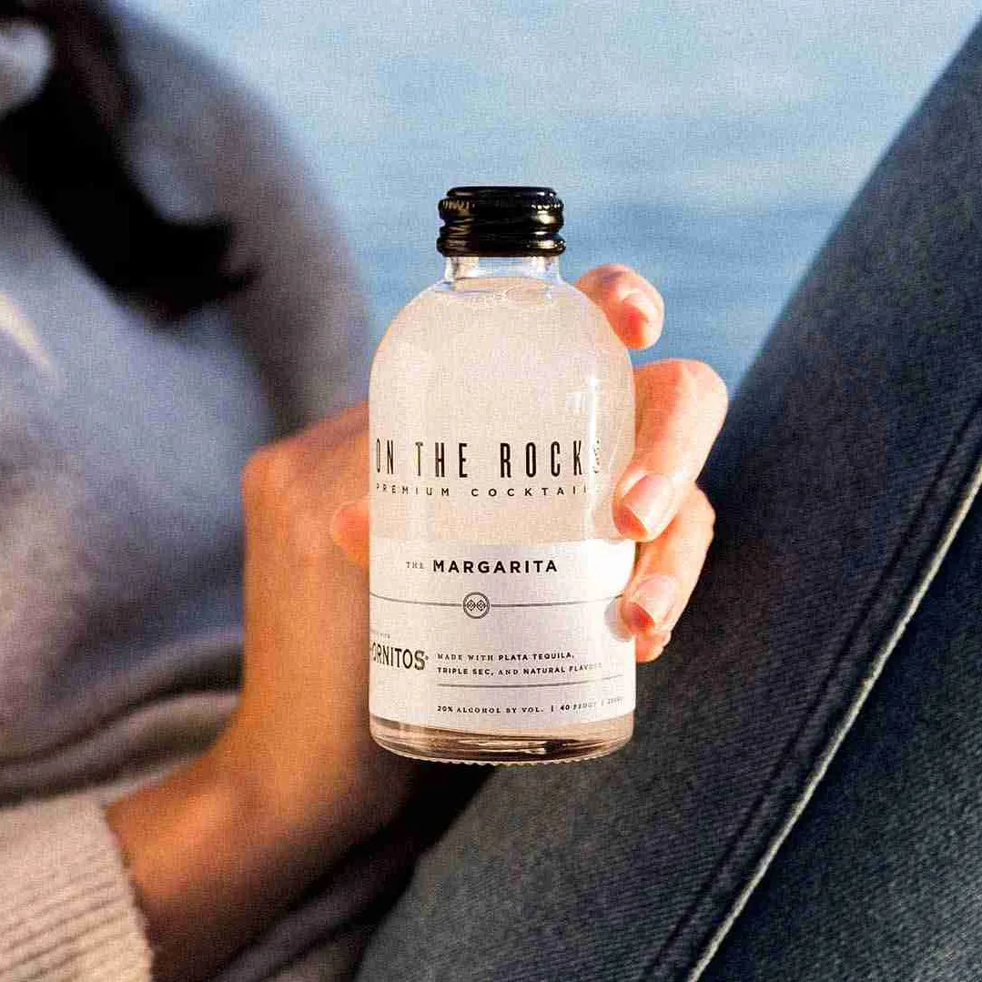 Woman holding a bottle of OTR Margarita cocktail