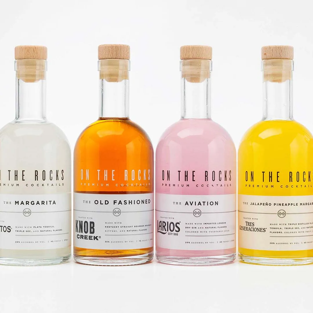 OTR cocktail bottles, filled with various shades of orange, pink, brown and white liquids against white background.