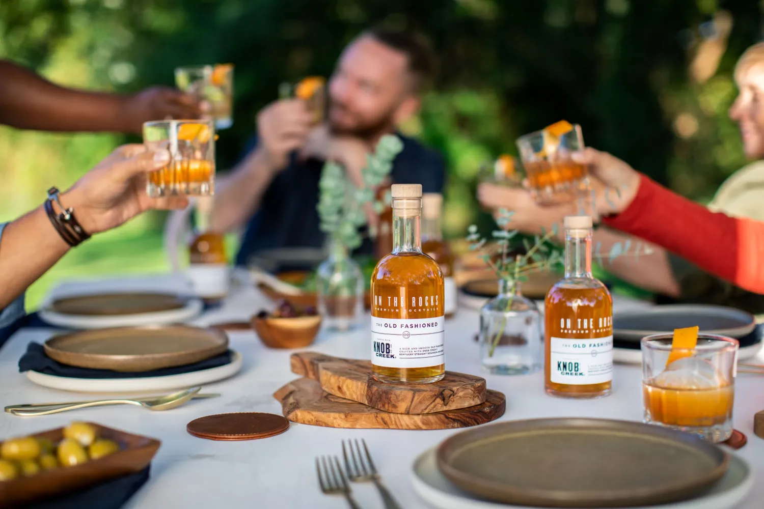 OTR Old Fashioned being served as the cocktail for an outdoor dinner party