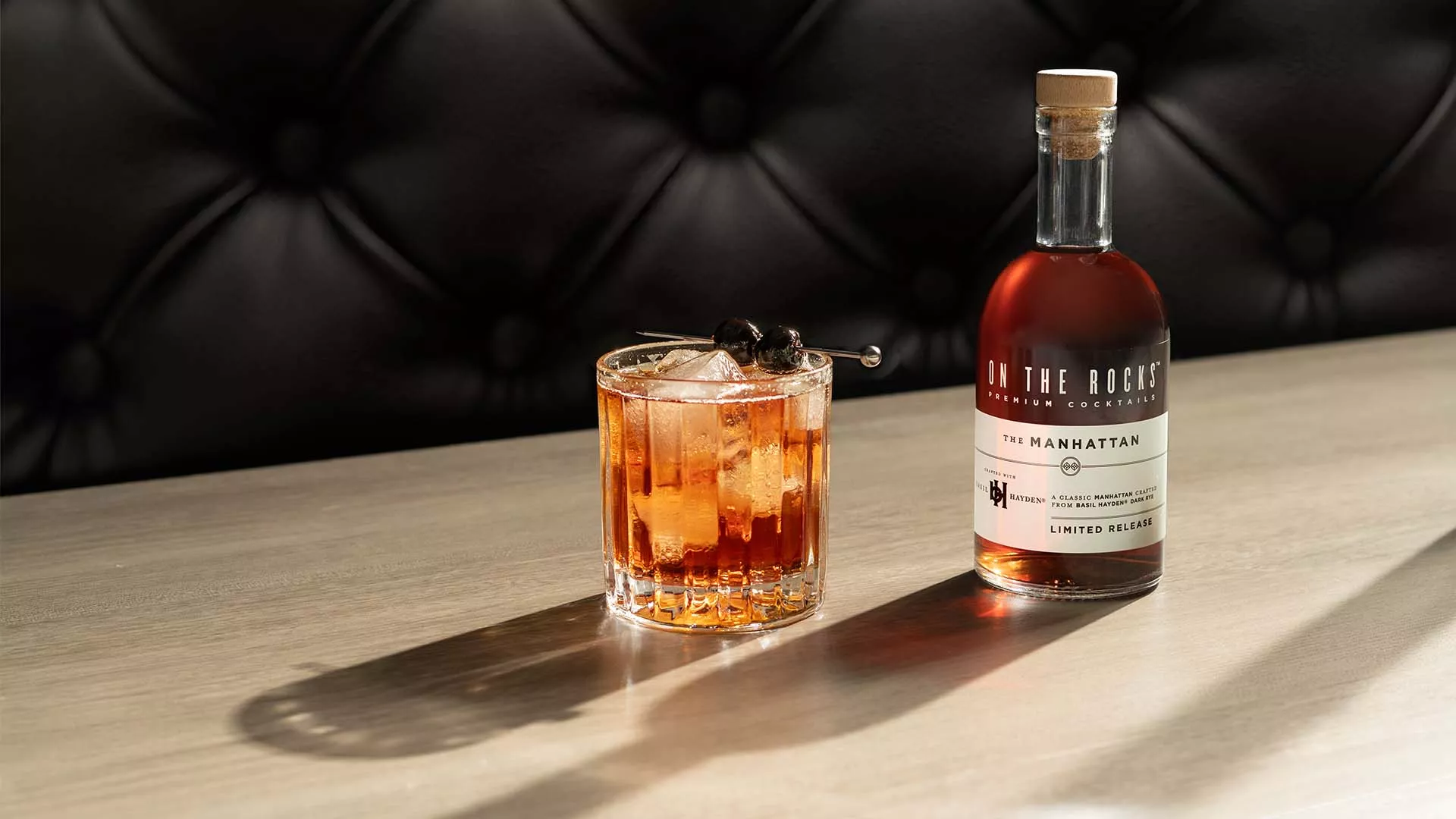 A bottle and a glass of OTR Manhattan cocktail at bar