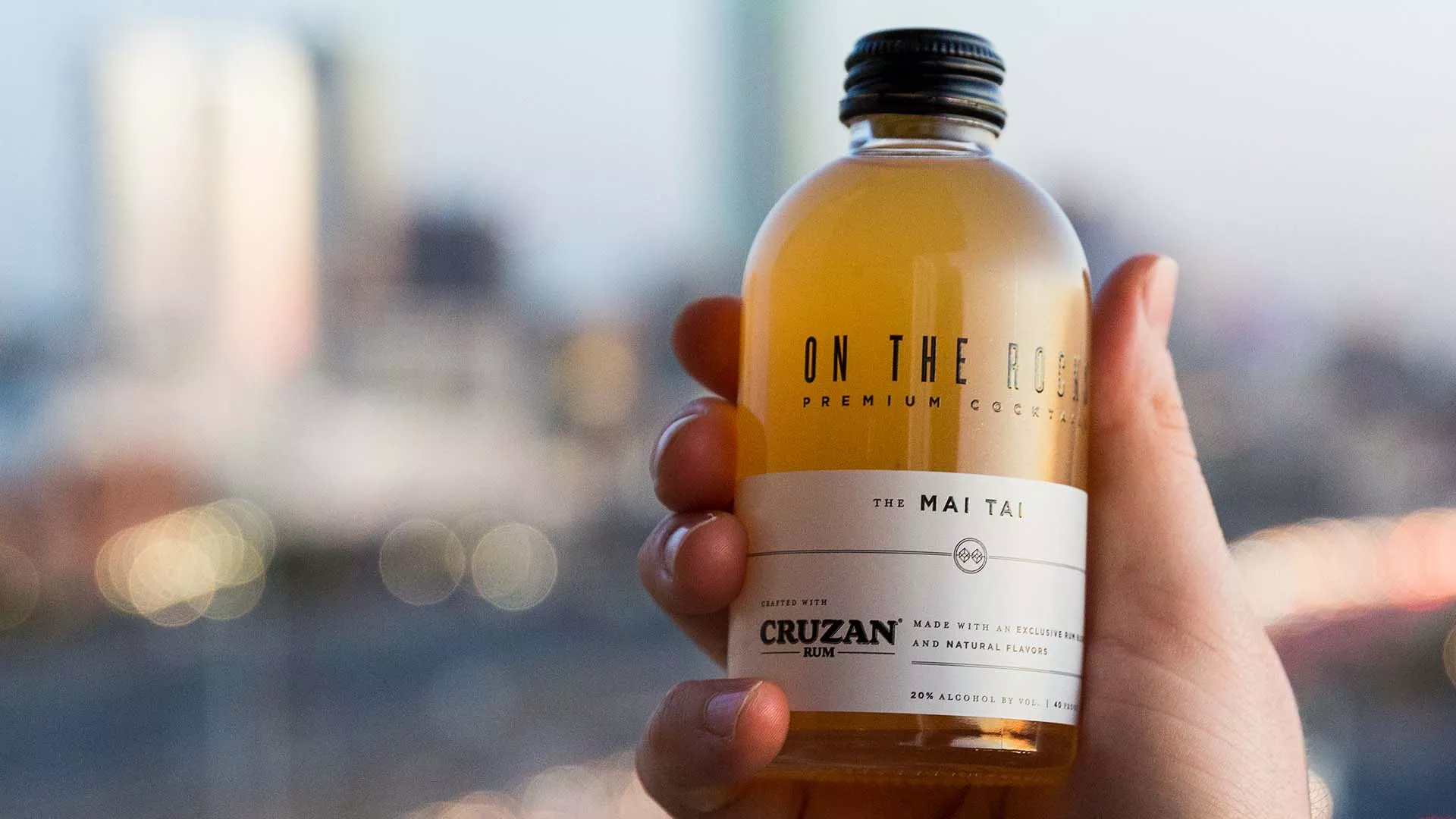 A hand holding a bottle of OTR Mai Tai cocktail