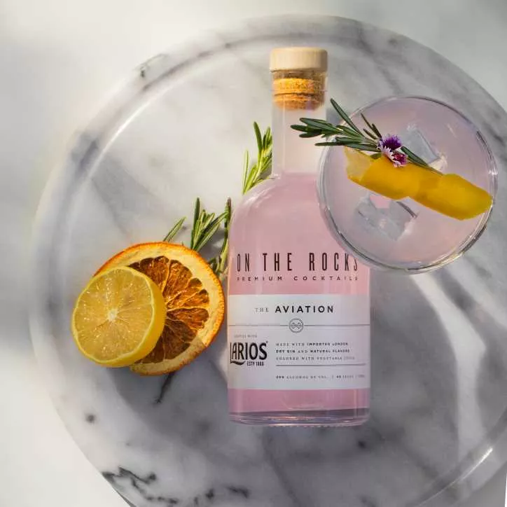 A bottle of On The Rocks Aviation on a marble cutting board