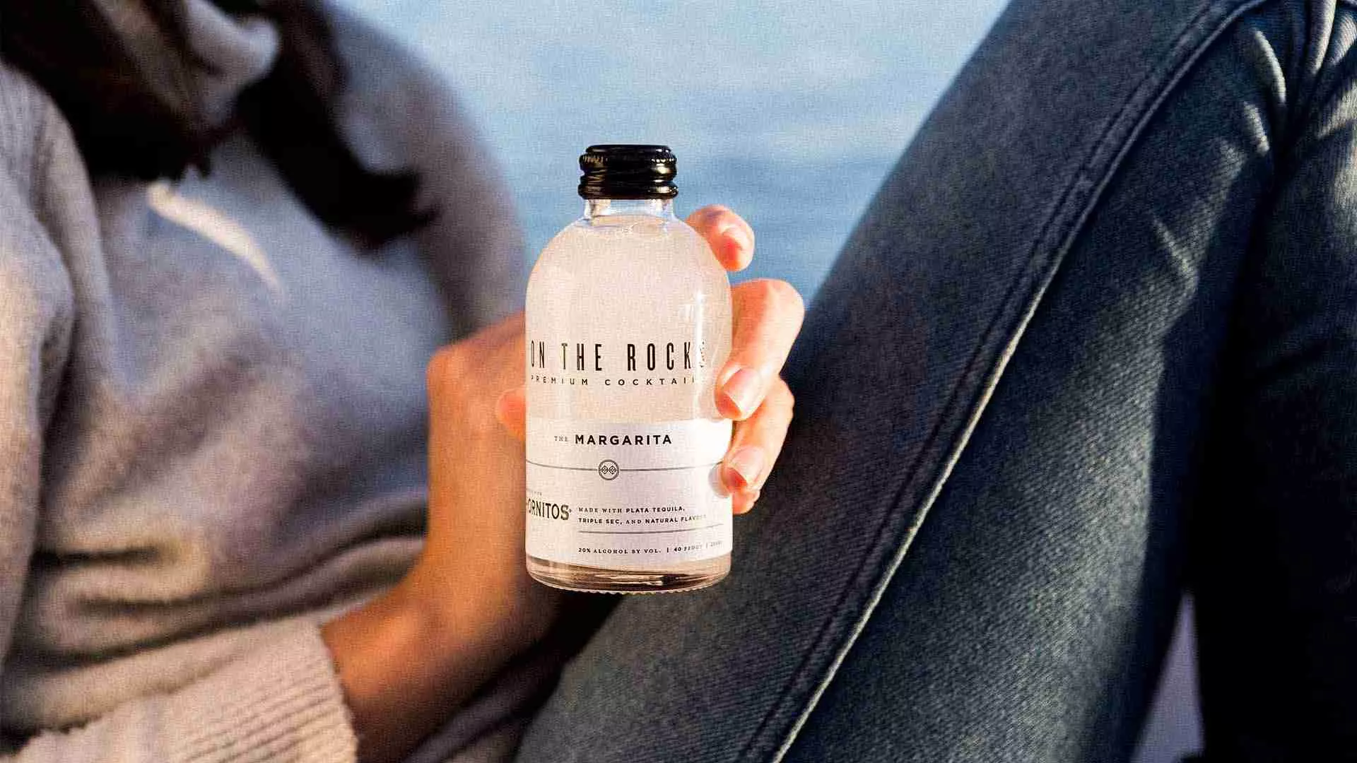Woman holding a bottle of OTR Margarita cocktail