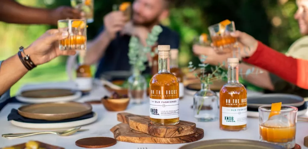 OTR Old Fashioned being served as the cocktail for an outdoor dinner party