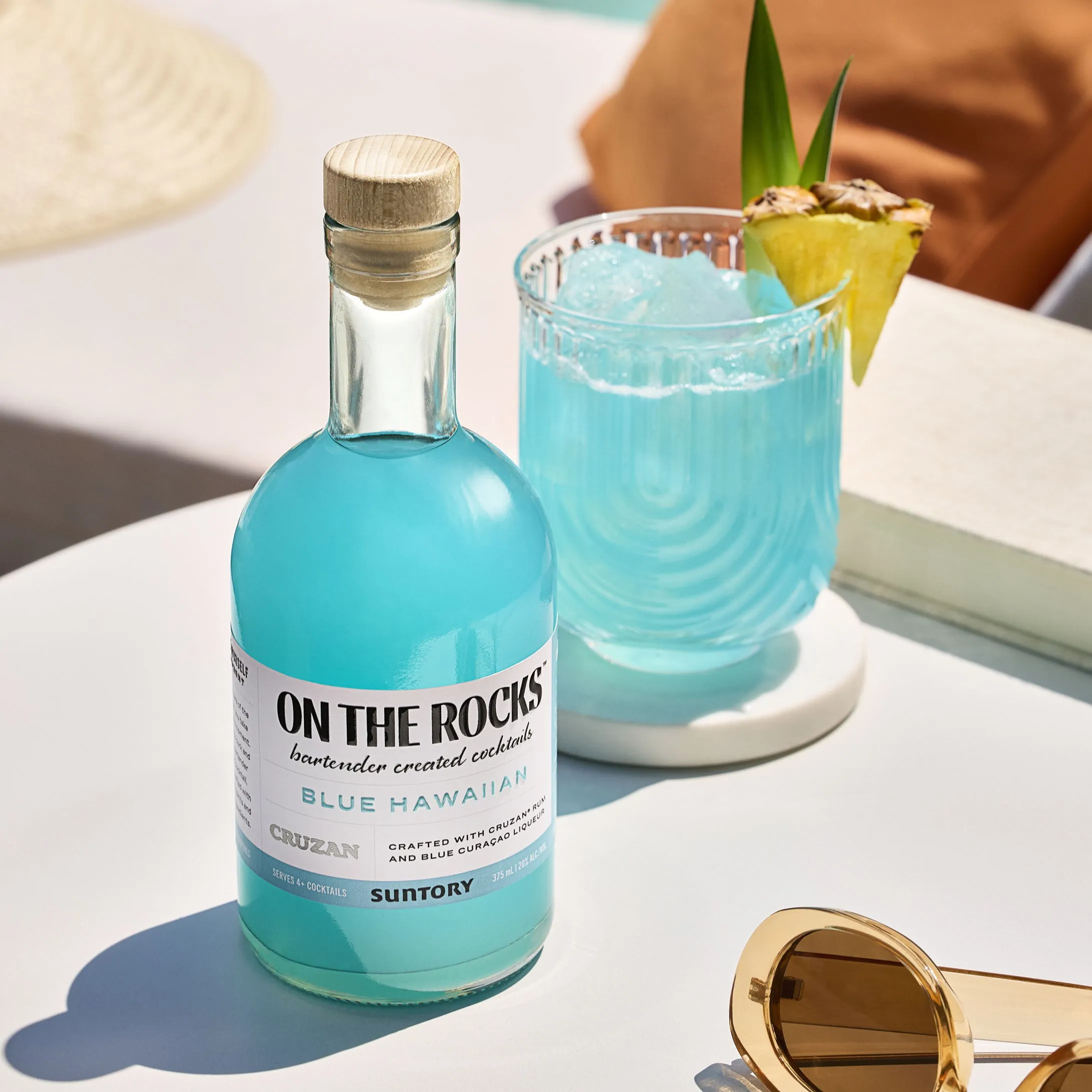 A bottle of on the rocks and the glass of the otr garnish with pineapple