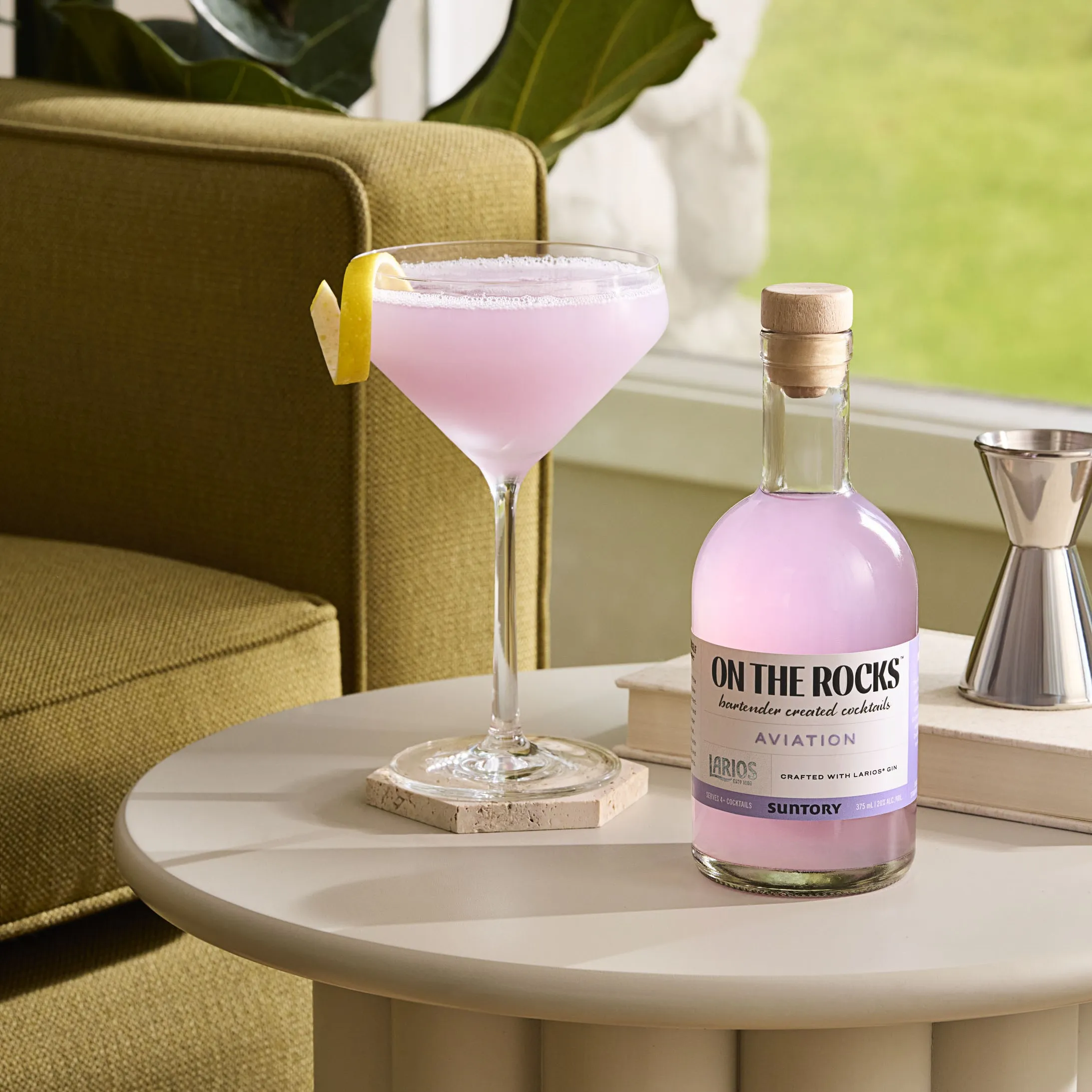 Bottle of the On the rock aviation and the class of the OTR garnish with lemon peel